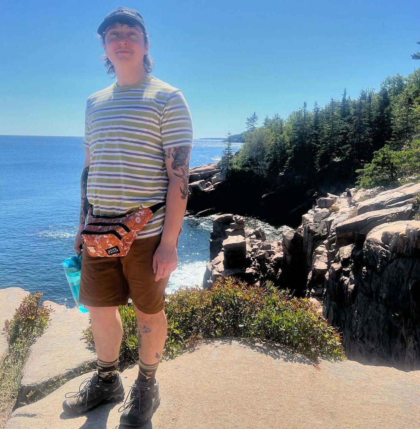 Clover Leman of Harbor Farm Wreaths standing on a seaside cliff at Acadia National Park in Bar Harbor Maine.